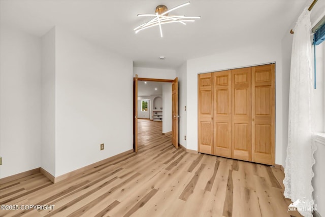 11510 Tulin Park Loop, Anchorage, AK 99516 - unfurnished bedroom with light wood finished floors, baseboards, and a closet