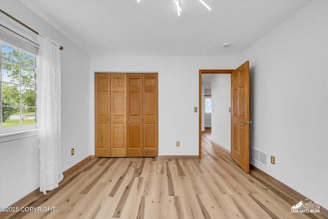 11510 Tulin Park Loop, Anchorage, AK 99516 - unfurnished bedroom with light wood-style floors, multiple windows, and baseboards