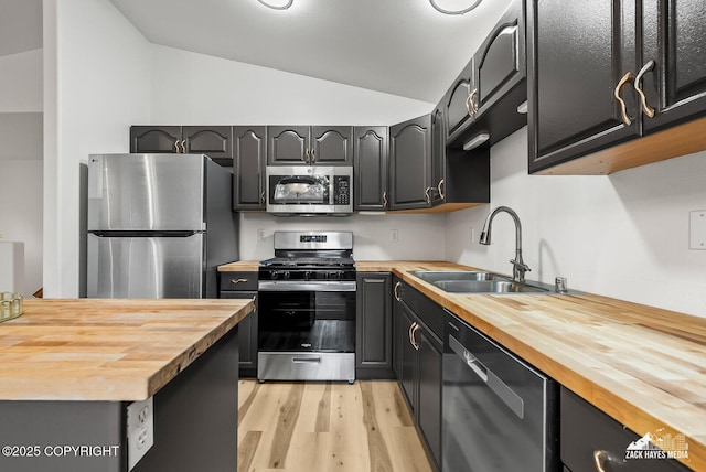 2578 Glacier St # 8, Anchorage, AK 99508 - kitchen featuring butcher block counters, stainless steel appliances, vaulted ceiling, and light wood-style floors