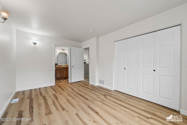 2578 Glacier St # 8, Anchorage, AK 99508 - unfurnished bedroom with light wood-type flooring, a closet, and ensuite bathroom
