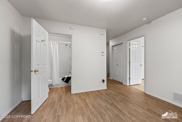 2578 Glacier St # 8, Anchorage, AK 99508 - unfurnished bedroom featuring light wood-style floors and connected bathroom