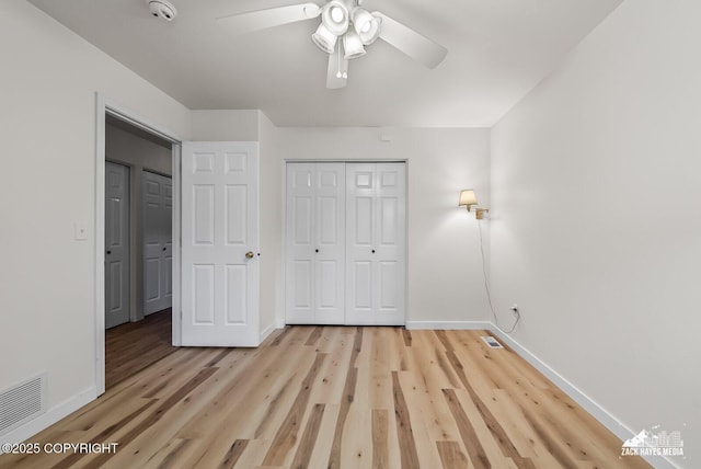 2578 Glacier St # 8, Anchorage, AK 99508 - unfurnished bedroom featuring light wood-style flooring, a closet, and a ceiling fan