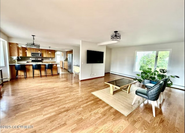 19440 Timberline Dr, Eagle River, AK 99577 - living room featuring a baseboard radiator, light wood-type flooring, and a chandelier