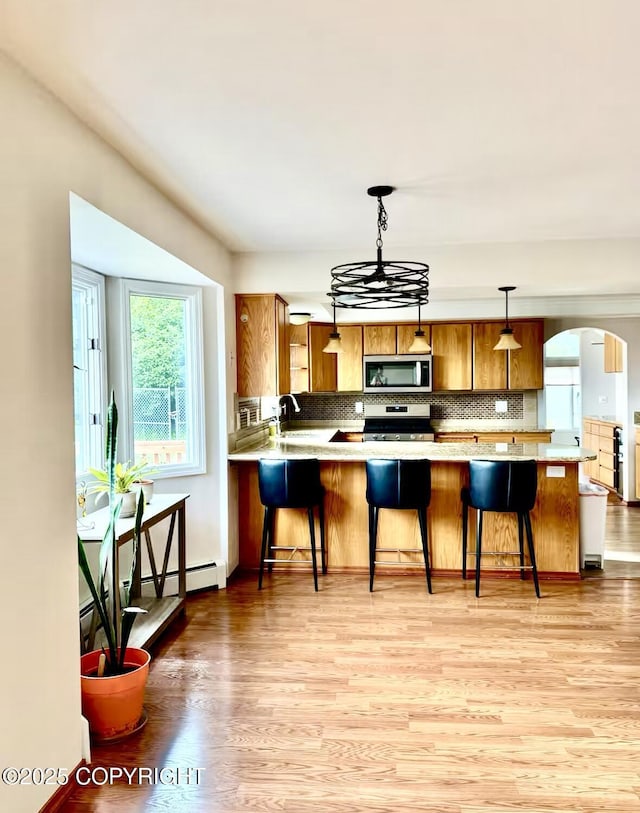 19440 Timberline Dr, Eagle River, AK 99577 - kitchen with appliances with stainless steel finishes, brown cabinets, and light wood-style floors