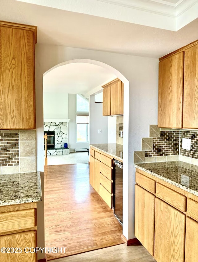 19440 Timberline Dr, Eagle River, AK 99577 - kitchen with light wood-style floors, backsplash, arched walkways, a glass covered fireplace, and crown molding