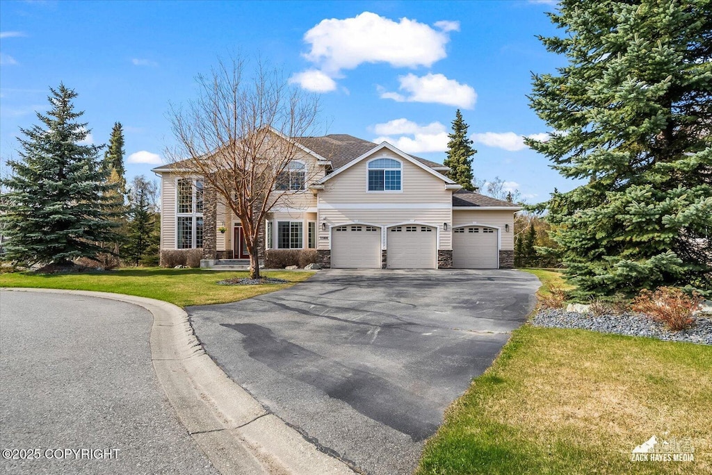 11166 Bluff Creek Cir, Anchorage, AK 99515 - traditional-style house with asphalt driveway, stone siding, a front lawn, and an attached garage