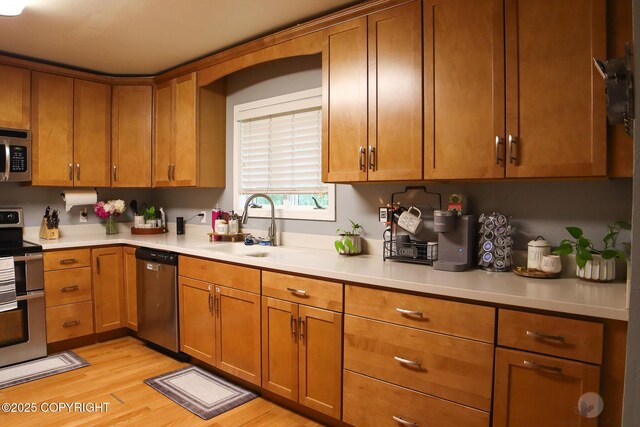 1468 Davison Rd, North Pole, AK 99705 - kitchen with stainless steel appliances, light countertops, a sink, and brown cabinetry