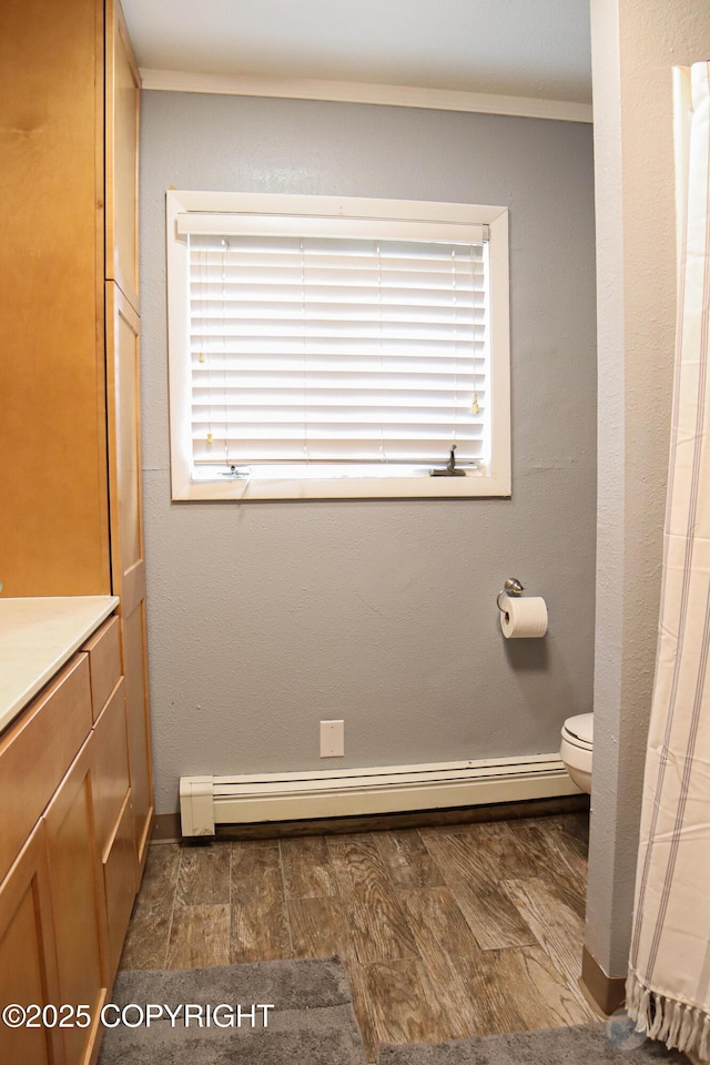 1468 Davison Rd, North Pole, AK 99705 - bathroom featuring a baseboard radiator, plenty of natural light, toilet, and ornamental molding