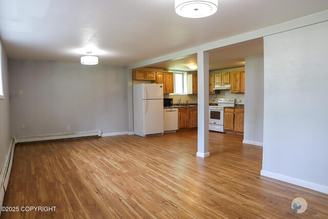 1468 Davison Rd, North Pole, AK 99705 - unfurnished living room featuring baseboard heating, baseboards, a sink, and light wood-style flooring