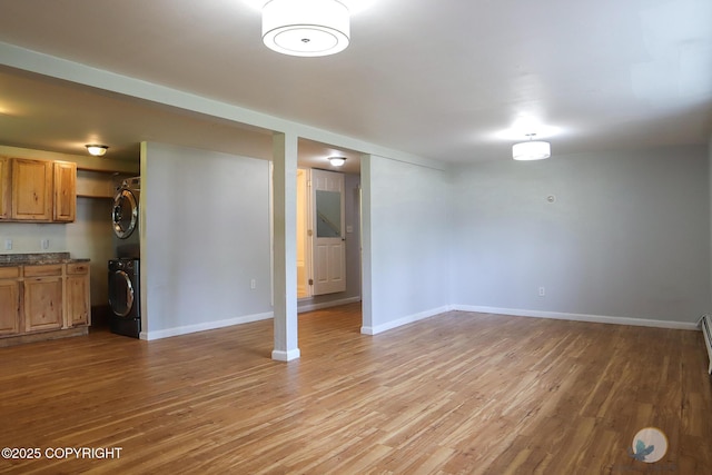 1468 Davison Rd, North Pole, AK 99705 - unfurnished living room with stacked washer and clothes dryer, light wood-style flooring, and baseboards