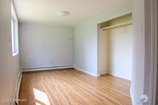 1468 Davison Rd, North Pole, AK 99705 - unfurnished bedroom with a baseboard heating unit, baseboards, and light wood-style floors