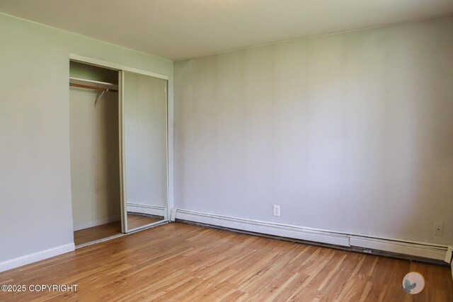 1468 Davison Rd, North Pole, AK 99705 - unfurnished bedroom featuring light wood finished floors, baseboards, a closet, and a baseboard radiator