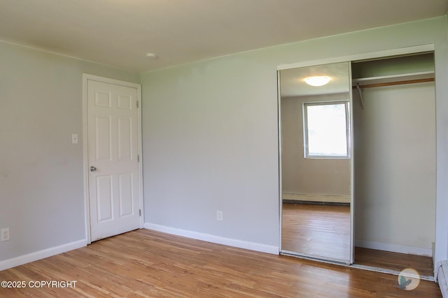 1468 Davison Rd, North Pole, AK 99705 - unfurnished bedroom featuring light wood finished floors, a baseboard heating unit, a closet, baseboards, and baseboard heating
