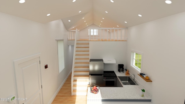 kitchen with stainless steel electric range, a sink, recessed lighting, and a healthy amount of sunlight