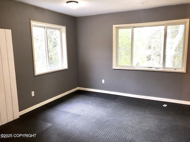 52899 Kingery Rd, Nikiski/North Kenai, AK 99611 - empty room featuring dark carpet, baseboards, and a wealth of natural light