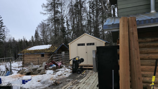 52899 Kingery Rd, Nikiski/North Kenai, AK 99611 - snow covered structure featuring an outbuilding, a shed, and a wooded view
