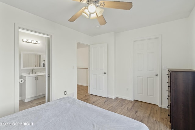 bedroom with ensuite bathroom, baseboards, ceiling fan, a sink, and light wood-style floors