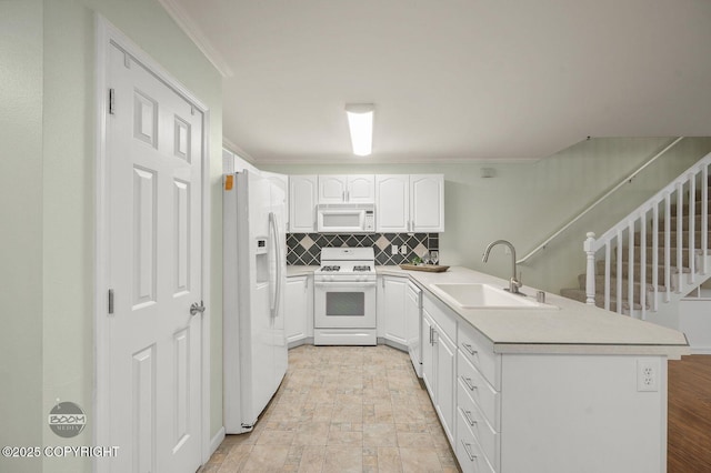 16627 River Heights Loop, Eagle River, AK 99577 - kitchen with white appliances, a sink, a peninsula, tasteful backsplash, and white cabinetry