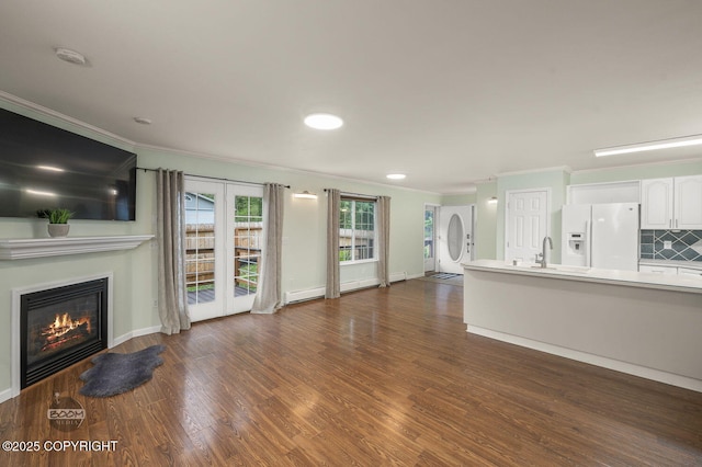 16627 River Heights Loop, Eagle River, AK 99577 - unfurnished living room featuring crown molding, a glass covered fireplace, dark wood-style flooring, a sink, and baseboards