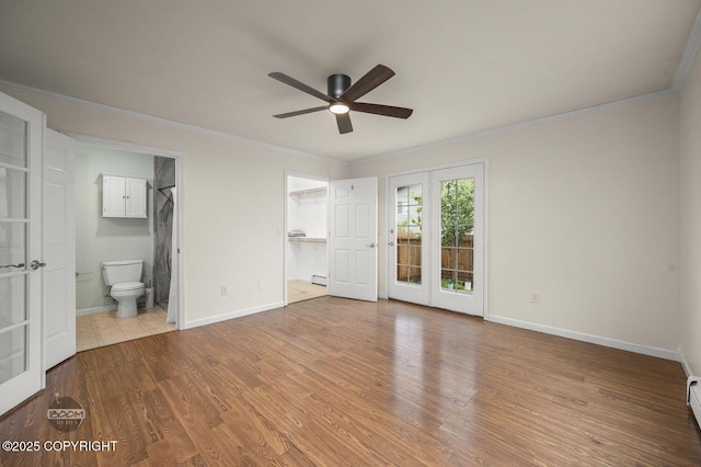 16627 River Heights Loop, Eagle River, AK 99577 - unfurnished bedroom featuring ornamental molding, a baseboard radiator, wood finished floors, baseboards, and a walk in closet