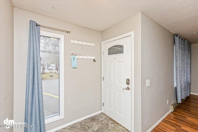 entryway with baseboards and a textured ceiling