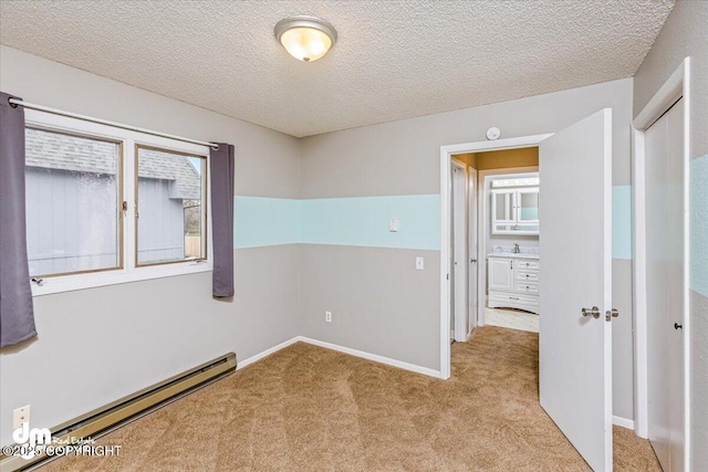 carpeted empty room featuring a textured ceiling and a baseboard radiator