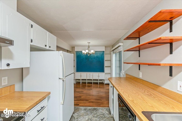 kitchen with white cabinets, open shelves, an inviting chandelier, dishwasher, and freestanding refrigerator