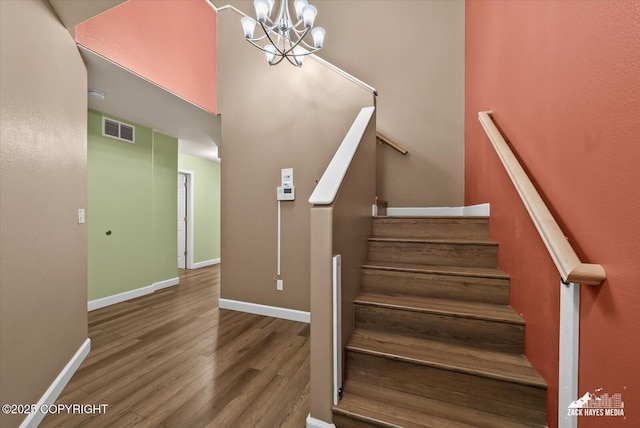 8041 Northwind Ave, Anchorage, AK 99504 - stairway featuring a chandelier, wood finished floors, and baseboards