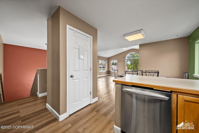 8041 Northwind Ave, Anchorage, AK 99504 - kitchen featuring stainless steel dishwasher, light wood-type flooring, vaulted ceiling, baseboards, and light countertops