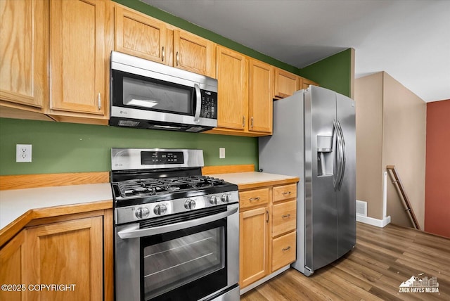 8041 Northwind Ave, Anchorage, AK 99504 - kitchen featuring stainless steel appliances, light countertops, light wood finished floors, and baseboards