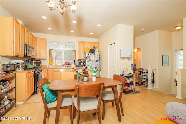 dining area with light wood finished floors, recessed lighting, and a chandelier
