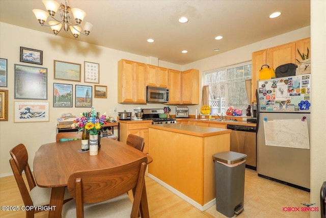 kitchen featuring appliances with stainless steel finishes, light brown cabinets, a sink, recessed lighting, and a kitchen island