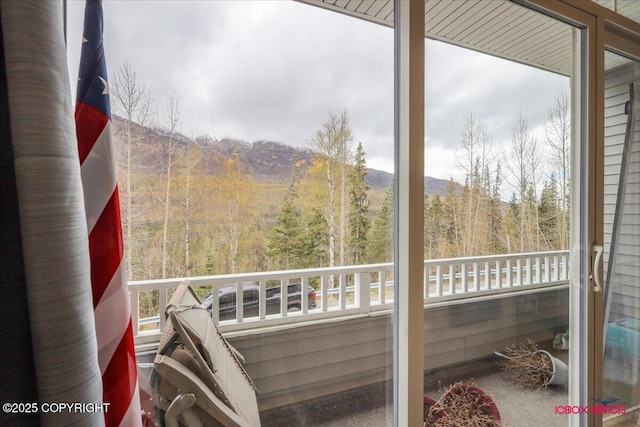 balcony with a wooded view and a mountain view