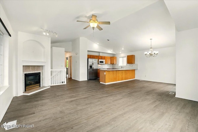 2308 Casey Cusack Loop, Anchorage, AK 99515 - unfurnished living room featuring vaulted ceiling, ceiling fan, a chandelier, dark wood finished floors, and a fireplace