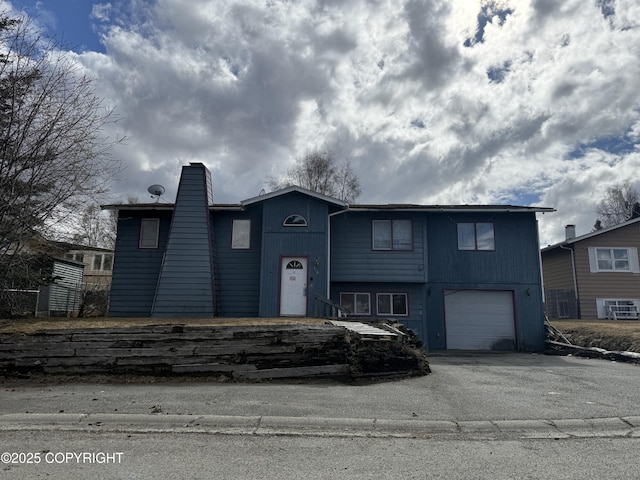 420 E 46th Pl, Anchorage, AK 99503 - raised ranch featuring an attached garage, a chimney, and driveway