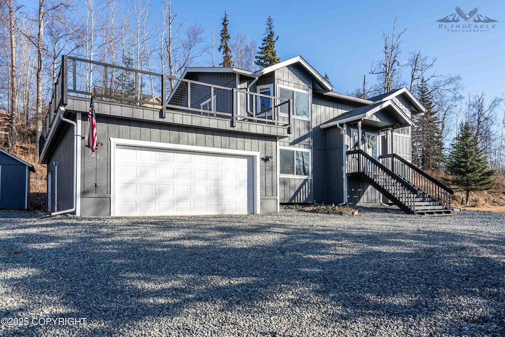 3285 W Wintergreen Dr, Wasilla, AK 99623 - view of front facade featuring a balcony, stairs, driveway, and a garage