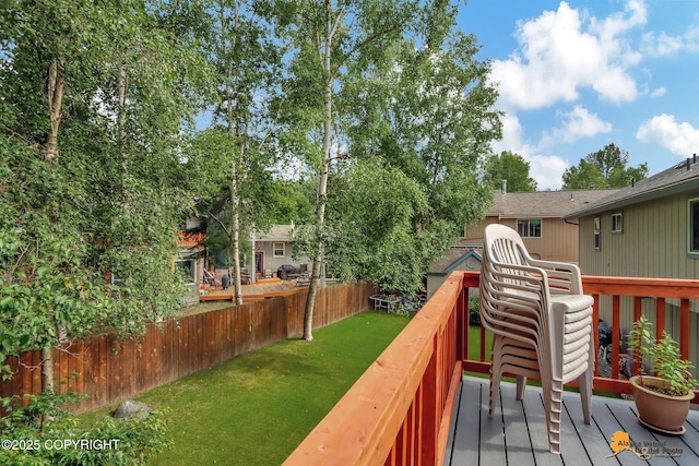 wooden deck with a lawn and fence