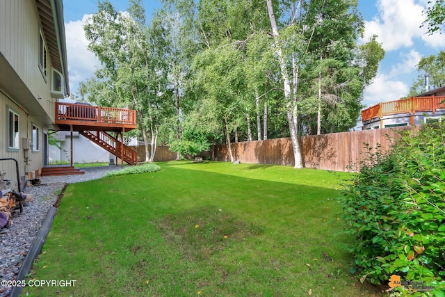 view of yard with stairway, a wooden deck, and a fenced backyard