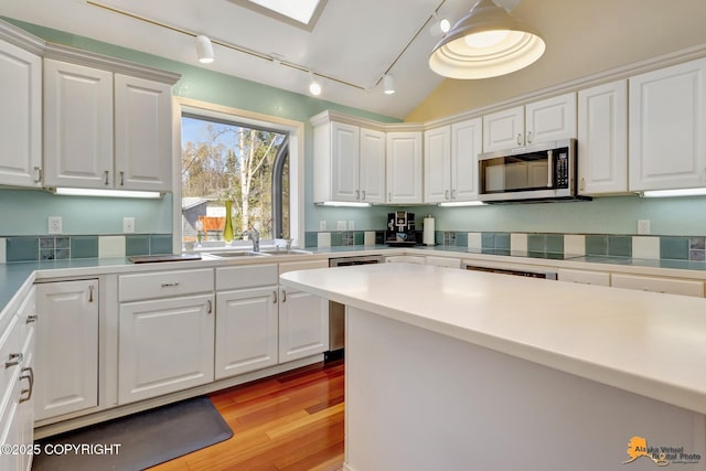 kitchen featuring track lighting, appliances with stainless steel finishes, light wood-style flooring, and white cabinetry