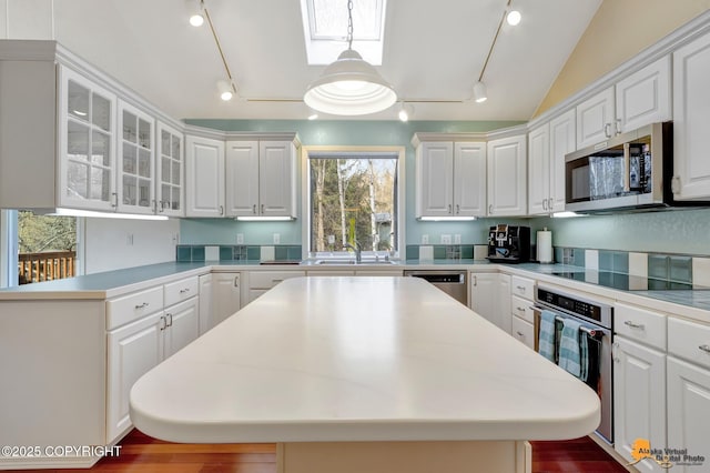 kitchen with white cabinetry, rail lighting, and appliances with stainless steel finishes