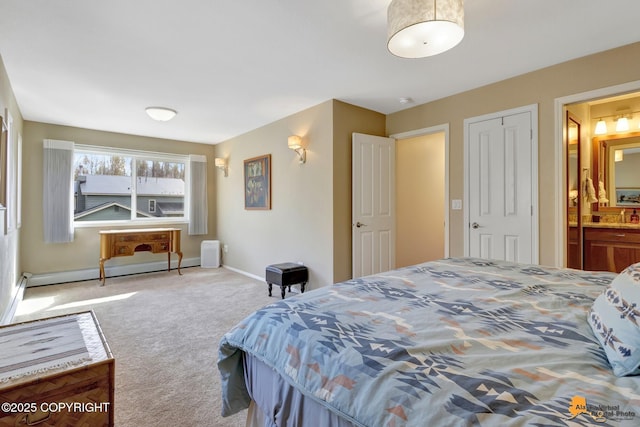 carpeted bedroom with baseboards, baseboard heating, and ensuite bath