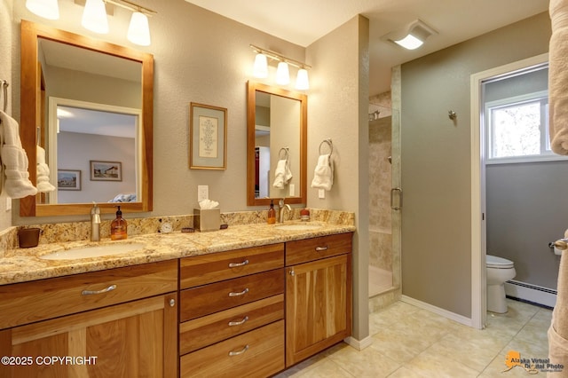 full bathroom with a sink, baseboard heating, a stall shower, and toilet