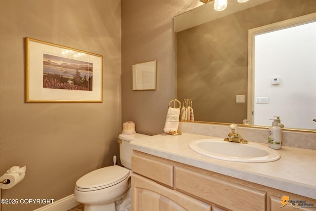 half bathroom featuring vanity and toilet
