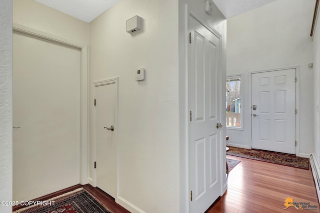 foyer featuring baseboards, baseboard heating, and hardwood / wood-style floors