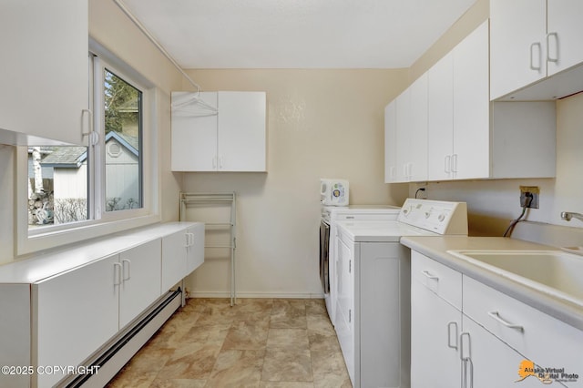 laundry room with cabinet space, a sink, baseboards, a baseboard radiator, and washing machine and dryer