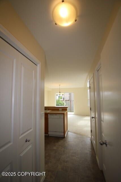 hall featuring dark colored carpet