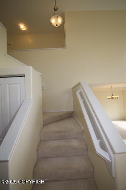 stairway with baseboards and carpet floors