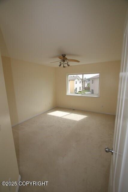 empty room with carpet flooring and a ceiling fan