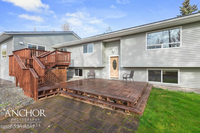 back of property featuring a wooden deck and a patio