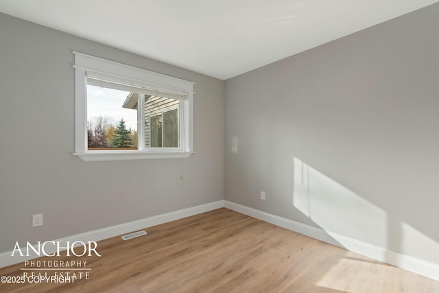 spare room with baseboards, visible vents, and light wood-style flooring